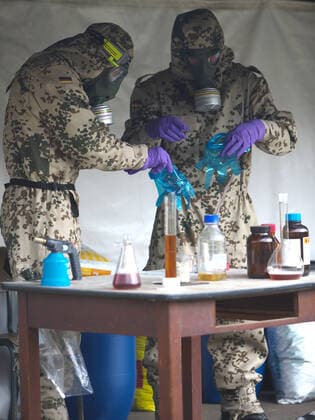 Bundeswehr soldiers of the NBC nuclear, biological, chemical defence force during an exercise The soldiers detect explosive ordnance, rescue persons and comrades under special protective clothing and decontaminate vehicles, areas and persons Soldiers of the NBC defence force during an exercise on the Bergen military training area on 25 09 2014 Bergen Lower Saxony Germany
