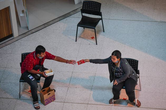 March 27, 2020, Bangkok, Thailand: People practice social distancing as they sit on chairs spread apart in a waiting area for take-away food orders at a shopping mall in hopes of preventing the spread of the coronavirus in Bangkok. Bangkok Thailand - ZUMAs197 20200327_zaa_s197_012 Copyright: xAmpholxThongmueangluangx