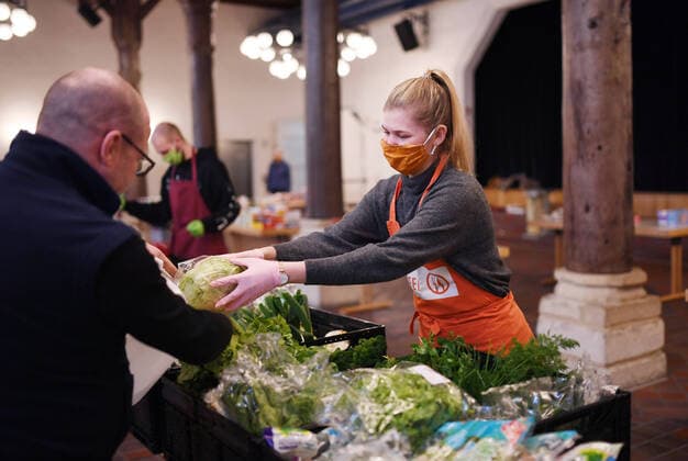 Rottenburg 27 03 2020 Start of the emergency operation of the Rottenburger Tafel in the Zehntscheuer, a volunteer with mouthguard and gloves at the food distribution ULMER