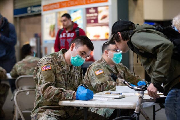 Members of the Rhode Island Army National Guard record information from arriving travelers inside Providence Train Station in Providence, Rhode Island on Thursday, March 27, 2020. The National Guard has been brought in to take down information of travelers coming into the state as part of public health tracking for COVID-19. Rhode Island Governor Gina Raimondo also announced that all visitors arriving from New York to the state will be required to self quarantine for 14 days.  PVD20200327103 MATTHEWxHEALEY