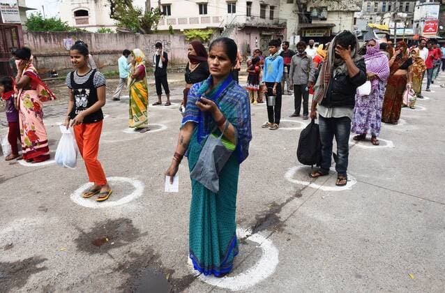 NEW DELHI, INDIA - MARCH 27: Homeless persons and stranded migrant workers queue up to receive food in designated spots maintaining social distancing, on day 3 of the three week nationwide lockdown to check the spread of Coronavirus COVID-19 , at Ramakrishna Ashram in Paharganj on March 27, 2020 in New Delhi, India. (Photo by Vipin Kumar Hindustan Times) Government Provide Food To Homeless And Poor Amid Lockdown To Prevent Covid 19