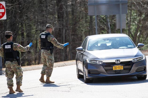 A member of the Rhode Island Army National Guard directs a vehicle with New York license plates at a rest area in Richmond, Rhode Island on Friday, March 27, 2020. The State Police and Rhode Island Army National Guard are helping to enforce a mandatory 14-day quarantine for all visitors from New York state as part of Rhode Island s COVID-19 response. Rhode Island Governor Gina Raimondo announced the new quarantine restrictions for New Yorkers during her press conference on Thursday.  PVD20200327120 MATTHEWxHEALEY