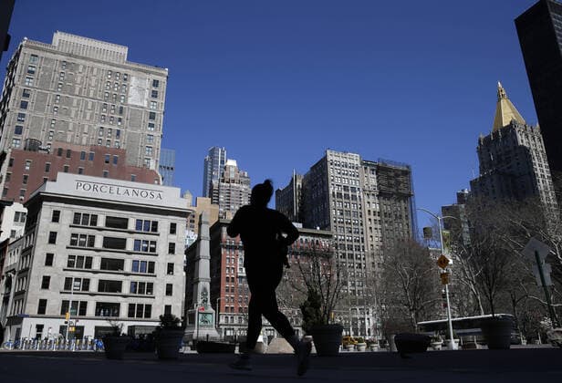 A jogger runs near a quiet of pedestrian and vehicle traffic Madison Square Park and Flatiron Public Plaza in New York City on Friday, March 27, 2020. Almost half of the United States are under stay-at-home orders and the United States has become the country with the most confirmed coronavirus cases at over 94,000.  NYP20200327109 JOHNxANGELILLO