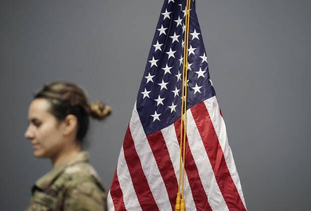 Members of the New York National Guard exit by walking by an American Flag after Gov. Andrew Cuomo speaks with the New York National Guard on site at the Jacob K. Javits Convention Center in New York City on Friday, March 27, 2020. The Javits Center is setting up to be turned into field hospitals to test and possibly treat cases of COVID-19 infections. Almost half of the United States are under stay-at-home orders and the United States has become the country with the most confirmed coronavirus cases at over 94,000.  NYP20200327116 JOHNxANGELILLO