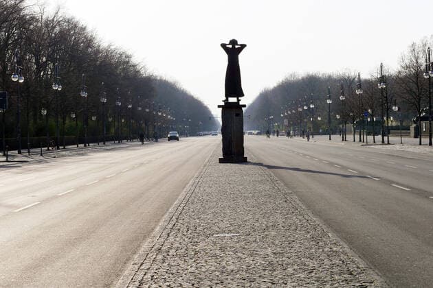 27 03 2020, Berlin Germany Corona crisis ghostly emptiness on the Road of June 17, almost no traffic, no cars, but the silhouette of the monument Der Rufer