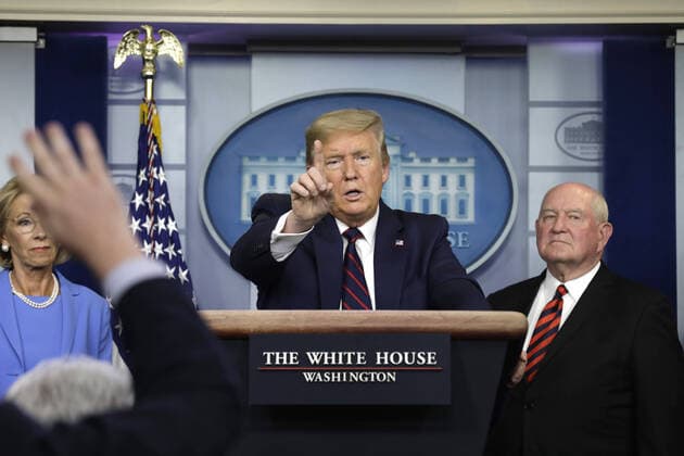 U.S. President Donald Trump speaks between Education Secretary Betsy DeVos (L) and Agriculture Secretary Sonny Perdue during a press briefing on the Coronavirus COVID-19 pandemic with members of the Coronavirus Task Force at the White House in Washington, DC on Friday, March 27, 2020.  WAX20200327208 YURIxGRIPAS