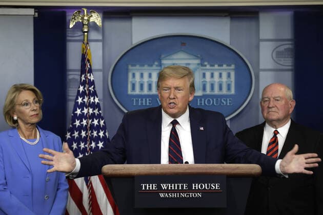 U.S. President Donald Trump speaks between Education Secretary Betsy DeVos (L) and Agriculture Secretary Sonny Perdue during a press briefing on the Coronavirus COVID-19 pandemic with members of the Coronavirus Task Force at the White House in Washington, DC on Friday, March 27, 2020.  WAX20200327214 YURIxGRIPAS