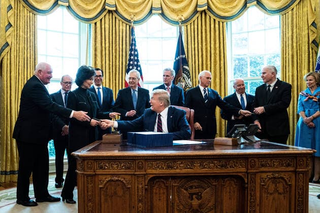 United States President Donald J. Trump hands a pen to United States Secretary of Agriculture Sonny Perdue, left, after signing ceremony the two trillion dollar coronavirus relief bill in the Oval Office at the White House in Washington, DC on March 27, 2020. From left to right behind the President: Secretary Perdue; Director of the National Economic Council Larry Kudlow; US Secretary of Transportation Elaine Chao; US Secretary of the Treasury Steven T. Mnuchin; US Senate Majority Leader Mitch McConnell (Republican of Kentucky); US House Minority Leader Kevin McCarthy (Republican of California); US Vice President Mike Pence; US Representative Kevin Brady (Republican of Texas); US Representative Steve Chabot (Republican of Ohio); and US Representative Liz Cheney (Republican of Wyoming). Copyright: xErinxSchaffx