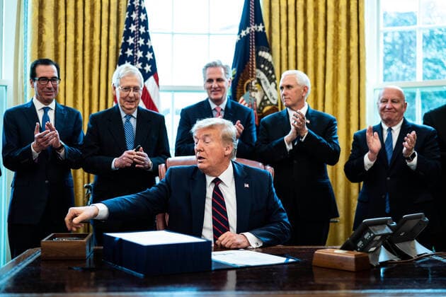March 27, 2020, Washington, District of Columbia, USA: United States President Donald J. Trump reaches for a pen to sign the two trillion dollar coronavirus relief bill in the Oval Office at the White House in Washington, DC on March 27, 2020. Standing and applauding behind the President, from left to right: US Secretary of the Treasury Steven T. Mnuchin; US Senate Majority Leader Mitch McConnell (Republican of Kentucky); US House Minority Leader Kevin McCarthy (Republican of California); US Vice President Mike Pence; and US Representative Kevin Brady (Republican of Texas) Washington USA - ZUMAs152 20200327_zaa_s152_040 Copyright: xErinxSchaffx
