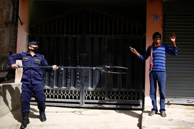March 28, 2020, Kathmandu, Nepal: A policeman arresting a lockdown violator using a multifunctional device that lets him maintain social distance on the fifth day of government imposed nationwide lockdown amid concerns over the coronavirus pandemic in Kathmandu, Nepal on Saturday, March 28, 2020. Kathmandu Nepal - ZUMAg200 20200328_zap_g200_006 Copyright: xSkandaxGautamx