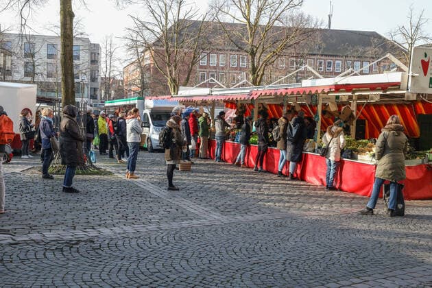 DEU, Germany, North Rhine-Westphalia, Münster, 28 03 2020 Shopping at the weekly market Due to the risk of corona infection, the weekly market has been equalised to create open spaces between stands for waiting customers In addition to the Domplatz, there are several market stands at the Prinzipalmarkt, Stands are also being set up at the Michaelisplatz The weekly market is well frequented and the distance