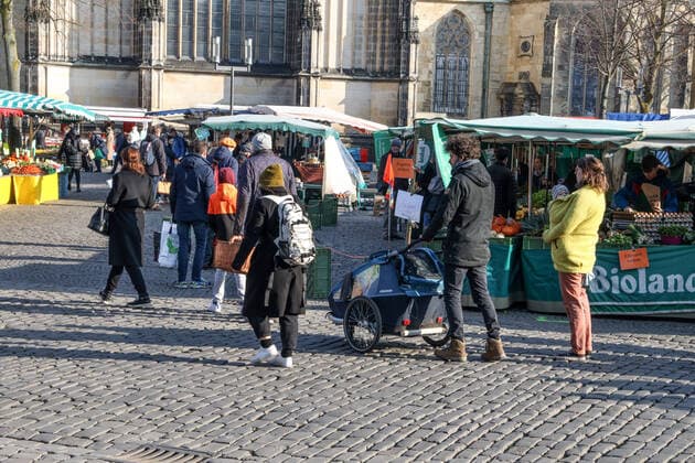 DEU, Germany, North Rhine-Westphalia, Münster, 28 03 2020 Shopping at the weekly market Due to the risk of corona infection, the weekly market has been equalised to create open spaces between stands for waiting customers In addition to the Domplatz, there are several market stands at the Prinzipalmarkt, Stands are also being set up at the Michaelisplatz The weekly market is well frequented and the distance