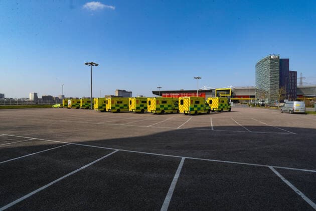 An overview picture looking at the Excel Exhibition Centre in East London, which is now the NHS Nightingale hospital that will deal with coronavirus outbreak patients. In the parking lot, NHS Support Unit personnel is seen deploying its medical support hardware equipment on Saturday morning, March 28, 2020. NHS Nightingale makeshift hospital is being made into a temporary 4000-bed, comprising of two wards, each of 2,000 people, to help tackle the coronavirus outbreak in Britain. (Photo Vudi Xhymshiti)  iMagoVX