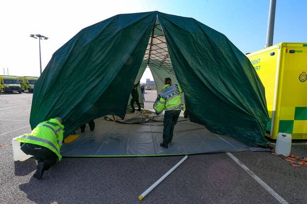 BRITAIN VIRUS OUTBREAK - NHS Support Unit personnel is seen setting up medical support hardware equipment at the ExCel Centre in London on Saturday, March 28, 2020. NHS Nightingale makeshift hospital is being made into a temporary 4000-bed, comprising of two wards, each of 2,000 people, to help tackle the coronavirus outbreak in Britain. (Photo Vudi Xhymshiti)  iMagoVX