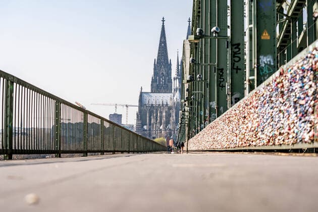 Almost empty Hohenzollern Bridge Almost people empty Hohenzollern Bridge on a Saturday noon with bright sunshine and pleasant temperatures Where usually every hour many hundreds of people stroll there are now only a few dozen on the road During the Corona crisis most people stay at home, despite the good weather Cologne Hohenzollern Bridge NRW Germany