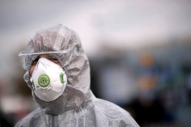 Germany-Poland Coronavirus Pandemic DEU, Deutschland, Germany, Brandenburg, Frankfurt Oder, 19.03.2020 Ein polnischer Grenzschutz und Gesundheitsbeamter mit einem Schutzanzug und einer Schutzmaske misst mit einem Temperaturmessgeraet die Temperatur von polnischen Buergern welche nach Polen zurueckkehren zum Schutz vor dem Coronavirus COVID-19 auf der Grenzbruecke zwischen Frankfurt an der Oder, Brandenburg, und Slubice in Polen. Polen hat aufgrund der hohen Zunahme von Coronafaellen in Deutschland seine Grenzen fuer EU Buerger geschlossen. A Polish border and health patrol guard wears a protection suit and a protective face mask while testing the temperatures of pedestrians and people crossing by car entering the town of Slubice Poland concerning the protection of the Coronavirus COVID-19 as European Union EU citizen movement restrictions