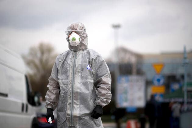 Germany-Poland Coronavirus Pandemic DEU, Deutschland, Germany, Brandenburg, Frankfurt Oder, 19.03.2020 Ein polnischer Grenzschutz und Gesundheitsbeamter mit einem Schutzanzug und einer Schutzmaske misst mit einem Temperaturmessgeraet die Temperatur von polnischen Buergern welche nach Polen zurueckkehren zum Schutz vor dem Coronavirus COVID-19 auf der Grenzbruecke zwischen Frankfurt an der Oder, Brandenburg, und Slubice in Polen. Polen hat aufgrund der hohen Zunahme von Coronafaellen in Deutschland seine Grenzen fuer EU Buerger geschlossen. A Polish border and health patrol guard wears a protection suit and a protective face mask while testing the temperatures of pedestrians and people crossing by car entering the town of Slubice Poland concerning the protection of the Coronavirus COVID-19 as European Union EU citizen movement restrictions