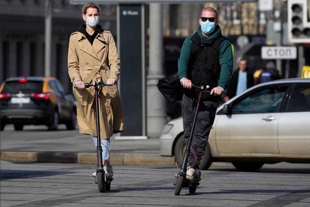 MOSCOW, RUSSIA - MARCH 28, 2020: Young people ride kick scooters, face masks on amid the ongoing COVID-19 pandemic. Sergei Bobylev TASS  TS0D3B26