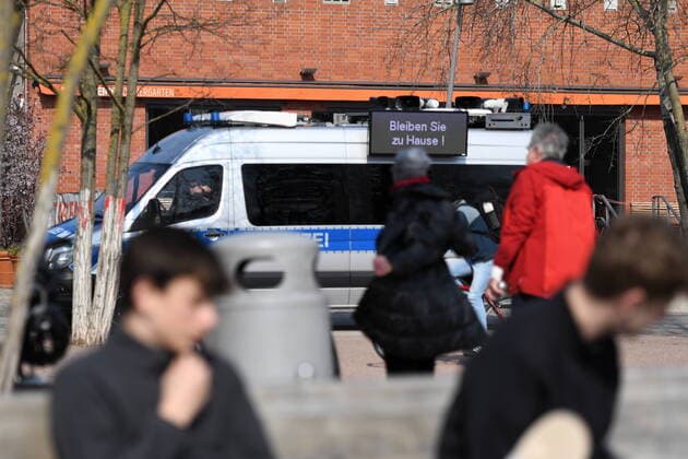 Berlin police officers make loudspeaker announcements and ask all those sitting or lying on the grass to move away Sporting or moving around is allowed On displays at the police car is allowed Stay at home Corona patrol at the triangular junction
