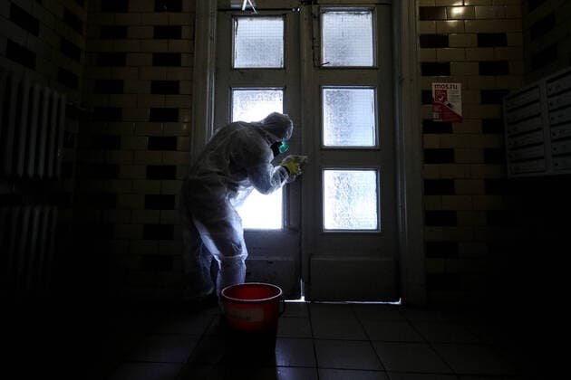 MOSCOW, RUSSIA - MARCH 28, 2020: A sanitary worker in a protective suit disinfects the front door in a block of flats in Moscow. Since 5 March, Moscow has been on high alert in connection with the pandemic of the novel coronavirus (COVID-19). Streets and other public areas are cleaned and disinfected to counter the spread of the novel coronavirus. As of 28 March 2020, Russia has reported more than 1200 confirmed cases of the novel coronavirus (COVID-19), with more than 800 confirmed cases in Moscow. Sergei Bobylev TASS  TS0D3B19
