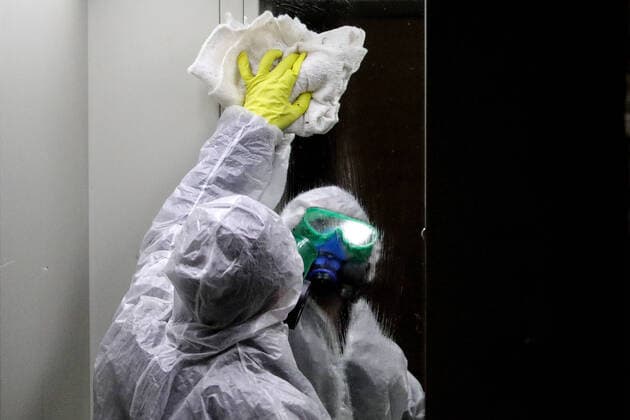 MOSCOW, RUSSIA - MARCH 28, 2020: A sanitary worker in a protective suit disinfects the front door in a block of flats in Moscow. Since 5 March, Moscow has been on high alert in connection with the pandemic of the novel coronavirus (COVID-19). Streets and other public areas are cleaned and disinfected to counter the spread of the novel coronavirus. As of 28 March 2020, Russia has reported more than 1200 confirmed cases of the novel coronavirus (COVID-19), with more than 800 confirmed cases in Moscow. Sergei Bobylev TASS  TS0D3B23