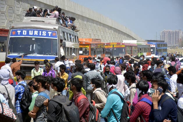 GHAZIABAD, INDIA - MARCH 28: Migrant workers wait for buses bound to their native state on Day 4 of the 21 day nationwide lockdown -- to check the spread of coronavirus, at Lal Kuan bus stand, on March 28, 2020 in Ghaziabad, India. (Photo by Sakib Ali Hindustan Times ) Coronavirus Update: Amid Lockdown, A Sea Of Migrants In Delhi-NCR Try To Find Their Way Back Home