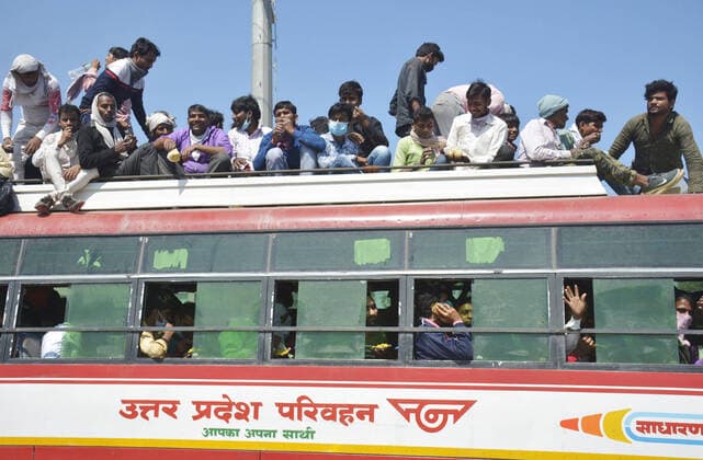 GHAZIABAD, INDIA - MARCH 28: Migrant workers head to their native state atop a bus during Day 4 of the 21 day nationwide lockdown -- to check the spread of coronavirus, at Lal Kuan bus stand, on March 28, 2020 in Ghaziabad, India. (Photo by Sakib Ali Hindustan Times ) Coronavirus Update: Amid Lockdown, A Sea Of Migrants In Delhi-NCR Try To Find Their Way Back Home