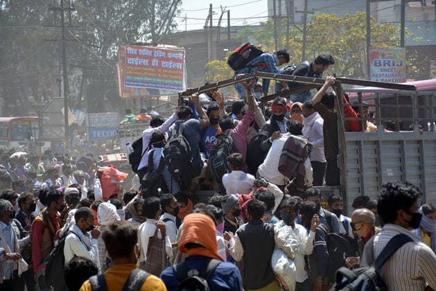 GHAZIABAD, INDIA - MARCH 28: Migrant workers try to board a goods truck bound to their native state during Day 4 of the 21 day nationwide lockdown -- to check the spread of coronavirus, at Lal Kuan bus stand, on March 28, 2020 in Ghaziabad, India. (Photo by Sakib Ali Hindustan Times ) Coronavirus Update: Amid Lockdown, A Sea Of Migrants In Delhi-NCR Try To Find Their Way Back Home