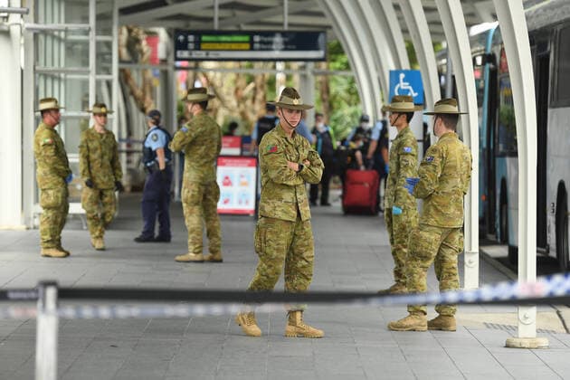 AUSTRALIA CORONAVIRUS COVID-19, A member of the Defence Force wait as returning overseas travellers are ushered towards waiting busses for the beginning of their 14-day imposed quarantine after arriving at Sydney International Airport in Sydney, Sunday, March 29, 2020. ( NO ARCHIVING, EDITORIAL USE ONLY, NO USE IN BOOKS WITHOUT CONSENT SYDNEY NSW AUSTRALIA  Copyright: xJOELxCARRETTx 20200329001460669880