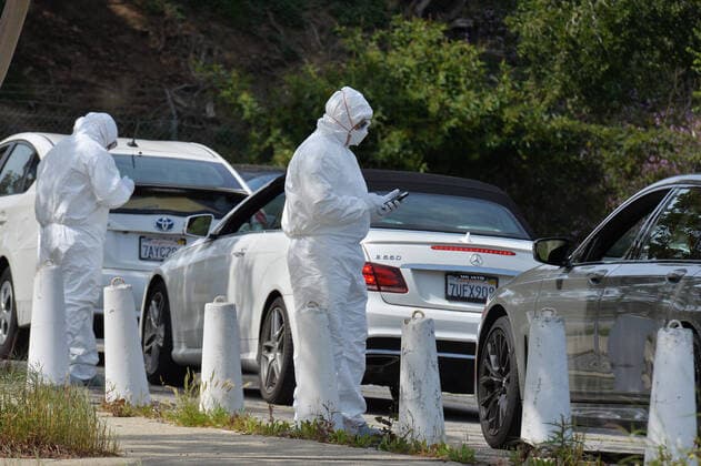 Medical and fire department personnel distribute self-testing coronavirus kits to residents who made appointments, in a parking lot adjacent to Dodger Stadium in Los Angeles on Saturday, March 28, 2020. The number of confirmed cases of COVID-19, the disease caused by the.coronavirus in Los Angeles County stood at 1,465 as of midday Saturday, with 26 deaths. The county s Department of Public Health reported 257 new cases on Friday, and 421 on Thursday, the highest one-day total so far.  LAP2020032809 JIMxRUYMEN