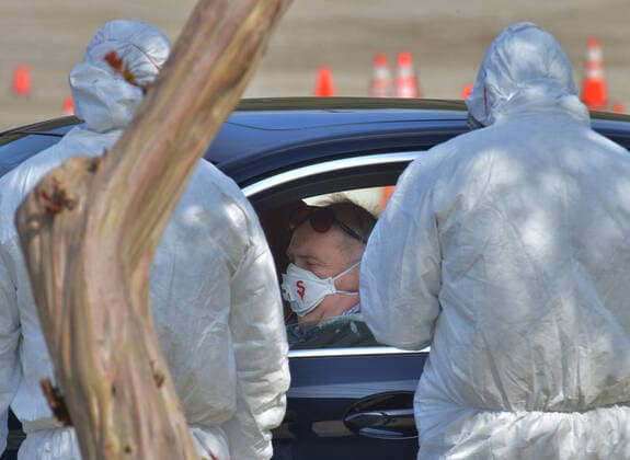 Medical and fire department personnel distribute self-testing coronavirus kits to residents who made appointments, in a parking lot adjacent to Dodger Stadium in Los Angeles on Saturday, March 28, 2020. The number of confirmed cases of COVID-19, the disease caused by the.coronavirus in Los Angeles County stood at 1,465 as of midday Saturday, with 26 deaths. The county s Department of Public Health reported 257 new cases on Friday, and 421 on Thursday, the highest one-day total so far.  LAP2020032821 JIMxRUYMEN