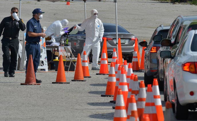 Medical and fire department personnel distribute self-testing coronavirus kits to residents who made appointments, in a parking lot adjacent to Dodger Stadium in Los Angeles on Saturday, March 28, 2020. The number of confirmed cases of COVID-19, the disease caused by the.coronavirus in Los Angeles County stood at 1,465 as of midday Saturday, with 26 deaths. The county s Department of Public Health reported 257 new cases on Friday, and 421 on Thursday, the highest one-day total so far.  LAP2020032824 JIMxRUYMEN