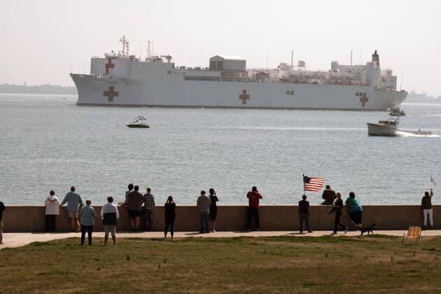 News Bilder des Tages March 28, 2020, Norfolk, Virginia, United States Of America: NORFOLK, VA - MARCH 28: People gather to watch the Military Sealift Command hospital ship USNS Comfort (T-AH 20) depart Naval Station Norfolk, Va., March 28, 2020. Comfort is deploying in support of the nations COVID-19 response efforts and will serve as a referral hospital for non-COVID-19 patients currently admitted to shore-based hospitals. This allows shore-based hospitals to focus their efforts on COVID-19 cases. One of the Department of Defenses missions is Defense Support of Civil Authorities. DoD is supporting the Federal Emergency Management Agency, the lead federal agency, as well as state, local and public health authorities in helping protect the health and safety of the American people. on March 28, 2020 in Norfolk, Virginia..People: USNS Comfort Norfolk Unit - ZUMAn287 20200328_zaa_n287_004 Copyright: xSMGx