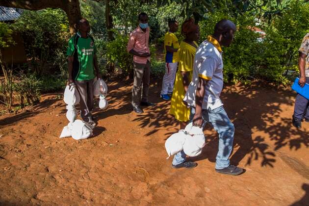 (200329) -- KIGALI, March 29, 2020 (Xinhua) -- People carry relief aid to vulnerable families that have been severely affected by a COVID-19 lockdown in Kigali, capital city of Rwanda, on March 28, 2020. The Rwandan Health Ministry on Saturday reported six new COVID-19 cases, bringing the total to 60. (Photo by Cyril Ndegeya Xinhua) RWANDA-KIGALI-COVID-19-RELIEF AID 