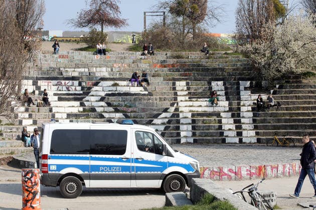 28 03 2020, Berlin Germany the warm weekend draws people outside in the Corona crisis The police patrol in Mauerpark People follow the rules and sit outside in the sun