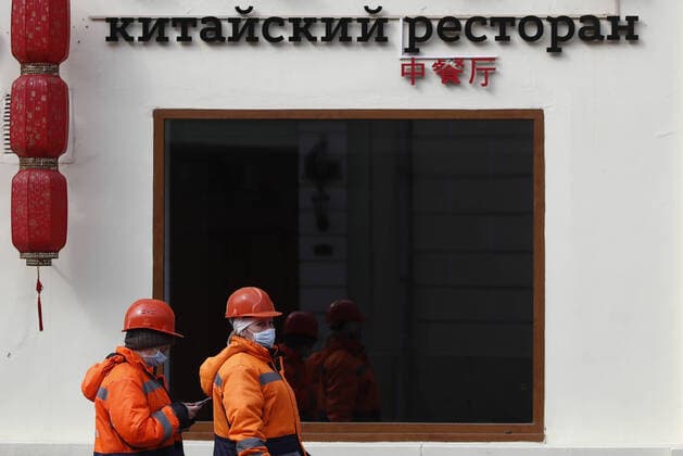 MOSCOW, RUSSIA - MARCH 29, 2020: Street cleaners in face masks are seen outside a shutdown Chinese food restaurant in Stary Arbat Street during the pandemic of the novel coronavirus (COVID-19). As of 29 March 2020, Russia has reported more than 1200 confirmed cases of the novel coronavirus (COVID-19), with more than 1000 confirmed cases in Moscow. Artyom Geodakyan TASS  TS0D3C5F