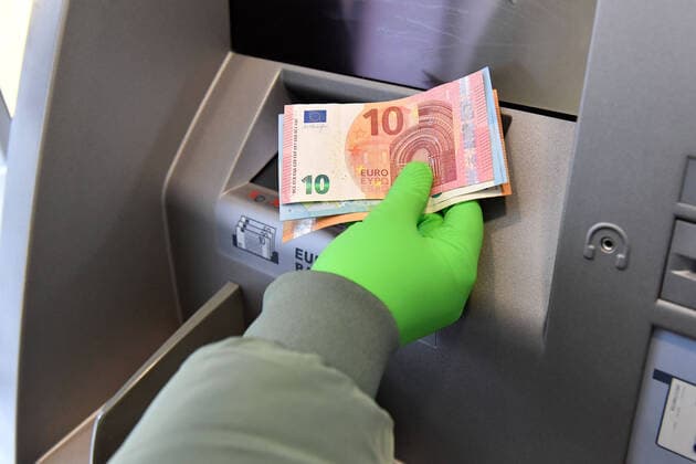 Withdrawing money from an ATM with protective gloves A customer takes his money from an ATM and wears green rubber gloves,Protective gloves Sven Simon Fotoagentur GmbH Co Pressefoto KG Prinzess Luise Str 41 45479 M u e l h e i m R u h r Tel 0208 9413250 Fax 0208 9413260 GLS Bank BLZ 430 609 67 Kto 4030 025 100 IBAN DE75 4306 0967 4030 0251 00 BIC GENODEM1GLS www svensimon net