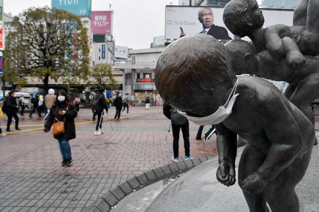 Pedestrians wearing face masks pass through a scramble crossing at Shibuya shopping district in Tokyo, Japan on Sunday, March 29, 2020. Streets in normally busy Tokyo areas such as the Shibuya, Shinjuku and Ginza shopping district are lightly populated.  TKP2020032917 KEIZOxMORI