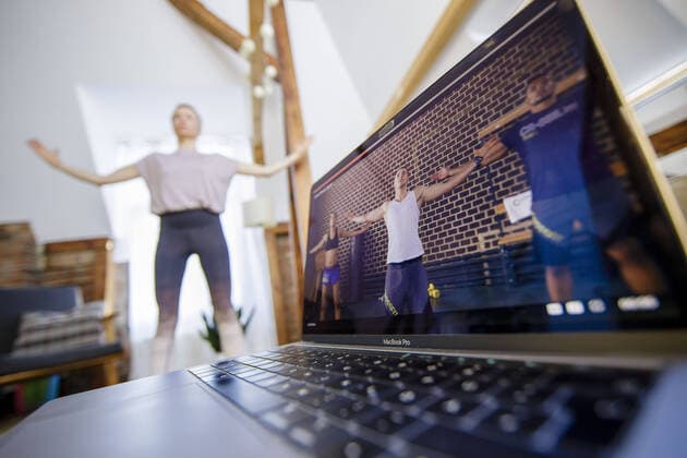 Symbolic photo on the subject of fitness A woman trains at home with the help of an online course on Gymondo Next to her is a laptop Berlin, 26 03 2020 Berlin Germany Copyright: xphotothek xThomasxTrutschelx