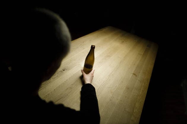 Symbol photo on the subject of alcoholism A woman sitting alone at home at a table holding a bottle of beer Berlin, 25 03 2020 Berlin Germany Copyright: xphotothek xThomasxTrutschelx