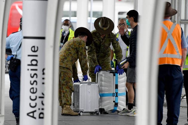 AUSTRALIA CORONAVIRUS COVID-19, Australian Defence Force (ADF) personnel watch over returning overseas travellers at Sydney International Airport in Sydney, Monday, March 30, 2020. Travellers and Australian residents who arrive into the country from overseas are being sent straight to makeshift quarantine facilities across Australia. Travellers will spend 14 days of quarantine in state-funded hotel rooms, with doors guarded by state police, defence personnel or private security guards.( NO ARCHIVING, EDITORIAL USE ONLY, NO USE IN BOOKS WITHOUT CONSENT SYDNEY NSW AUSTRALIA  Copyright: xBIANCAxDExMARCHIx 20200330001460797380