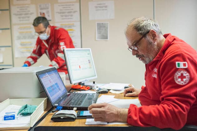 March 27, 2020, Milan, Italy: A member of the Red Cross seen coordinating the Crisis Unit..Due to the Covid-19 emergency, the Crisis Unit of the Red Cross Committee provide help to the citizens who need assistance in several municipalities, they offer commissions like food and medical supply, deliveries of prepared meals in hospitals, and ambulance services. Milan Italy - ZUMAs197 20200327_zaa_s197_164 Copyright: xValeriaxFerrarox