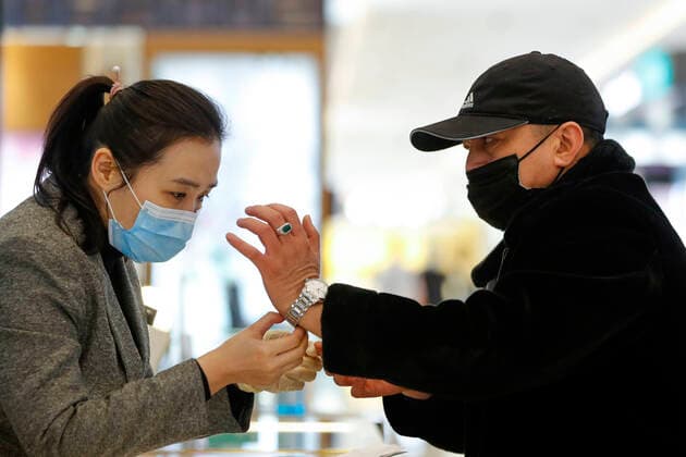 (200330) -- WUHAN, March 30, 2020 -- A customer selects a watch at a shopping mall in Wuhan, central China s Hubei Province, March 30, 2020. Many shopping malls in Wuhan reopened on Monday. ) CHINA-WUHAN-SHOPPING MALL-REOPENING (CN) ShenxBohan 