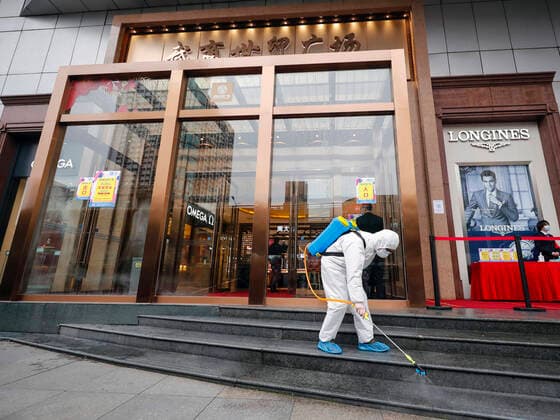 (200330) -- WUHAN, March 30, 2020 -- A staff member disinfects the entrance of a shopping mall in Wuhan, central China s Hubei Province, March 30, 2020. Many shopping malls in Wuhan reopened on Monday. ) CHINA-WUHAN-SHOPPING MALL-REOPENING (CN) ShenxBohan 