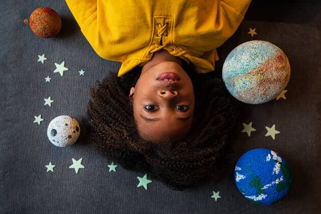 Weltkindertag am 20. September Overhead view of cute girl lying amidst solar system New York, NY, United States ,model released, Symbolfoto CR_LIWEEE200227-318409-01