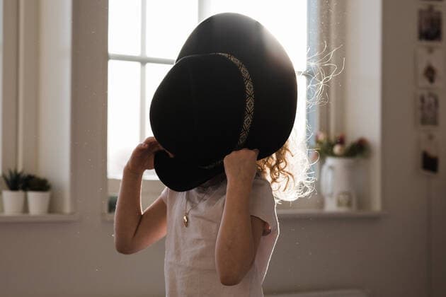 portrait of a young girl playing with a hat covering her face NorrtoÂ¤lje, Stockholm County, Sweden ,model released, Symbolfoto CR_RABE200302-305044-01