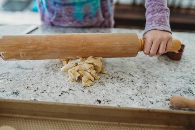 Girl rolling out dough in the kitchen with a rolling pin Massapequa, NY, United States ,model released, Symbolfoto CR_ERBU200304-318432-01