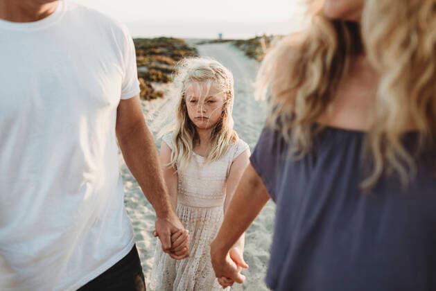 Serious girl making sad face walking with parents at beach San Diego, CA, United States ,model released, Symbolfoto CR_KESM200304B-212549-01