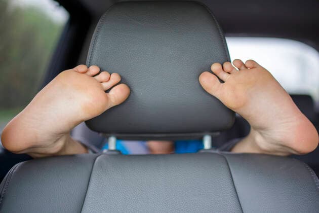 IMAGO Creative: Klimawandel - Nachhaltiges Reisen A child in the backseat of a car wraps his feet round the front seat Columbus, OH, United States ,model released, Symbolfoto CR_RETI200304C-251136-01