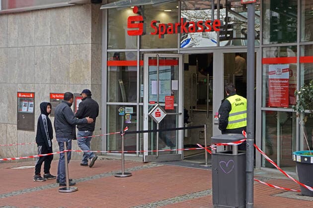 Fear of the coronavirus In the entrance area to a savings bank, a security service regulates access for customers Essen Nordrhein Westfalen Germany